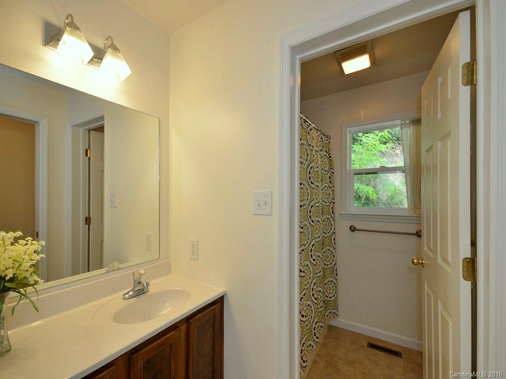 668 Mouzon Road Waynesville, NC 28785 - Photo 11 of 24 a bathroom with a sink a mirror and a shower