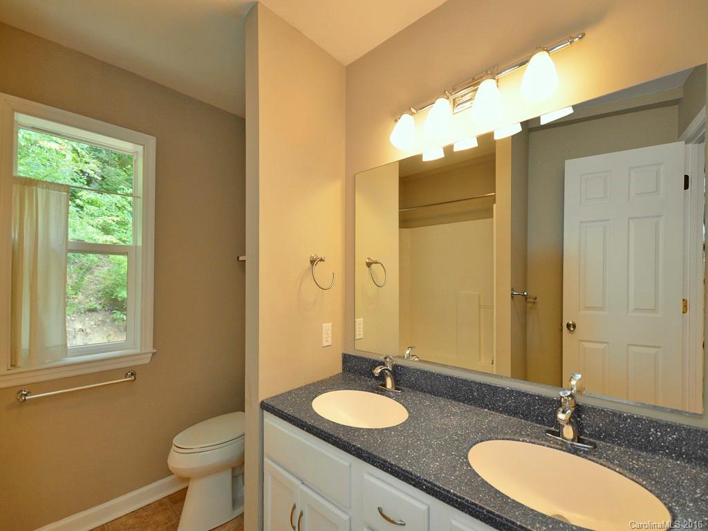 668 Mouzon Road Waynesville, NC 28785 - Photo 16 of 24 a bathroom with a granite countertop double vanity sinks a mirror and a toilet
