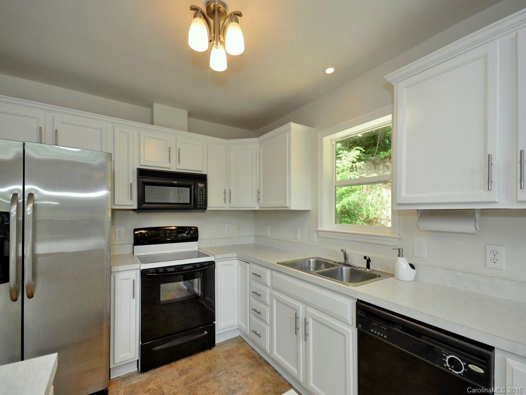 668 Mouzon Road Waynesville, NC 28785 - Photo 9 of 24 a kitchen with stainless steel appliances granite countertop a sink a stove a refrigerator cabinets and a window