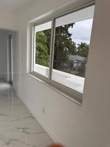 en empty room with windows and ceiling fan