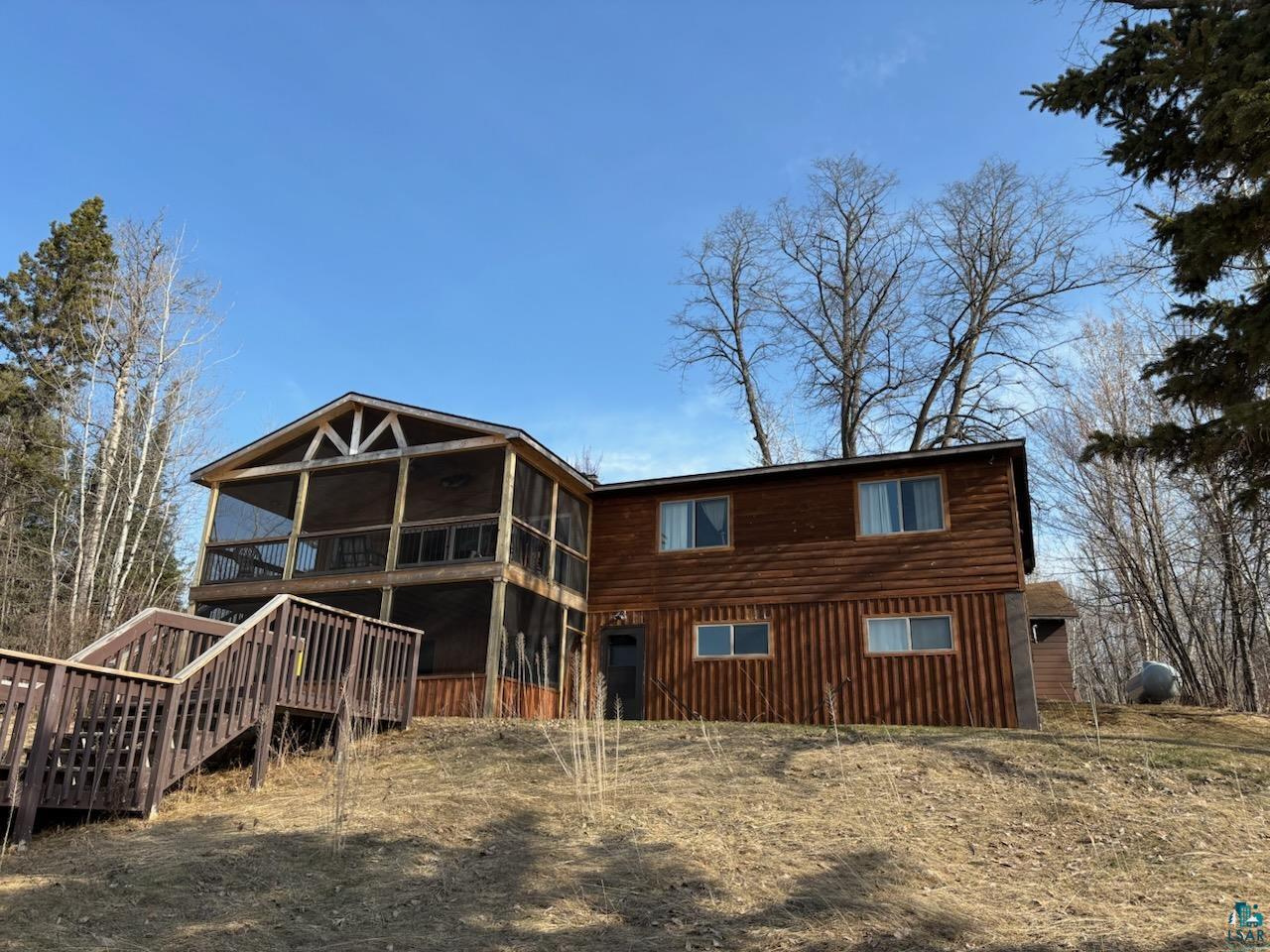 444 Fernberg Road, Unit 11 Ely, MN 55731 - Photo 1 of 19 Back of property featuring a wooden deck, a sunroom, and stairs