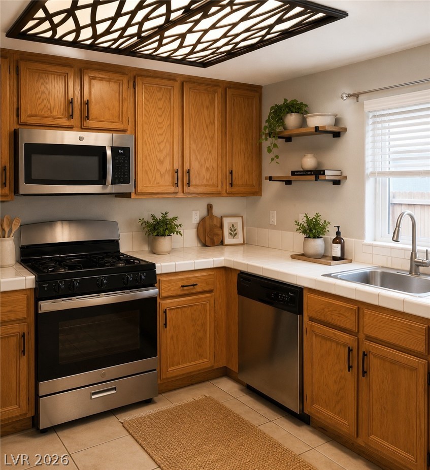346 Seine Way Henderson, NV 89014 - Photo 5 of 24 A compact kitchen with warm wood cabinetry and practical tile countertops awaits your culinary touch.