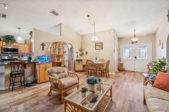 a living room with furniture and a view of kitchen