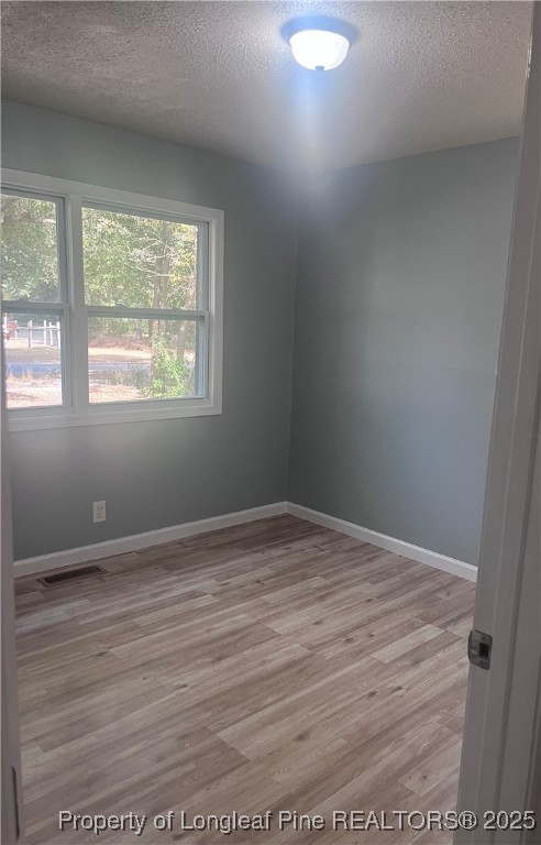 302 Keith Avenue Raeford, NC 28376 - Photo 11 of 14 an empty room with wooden floor and windows