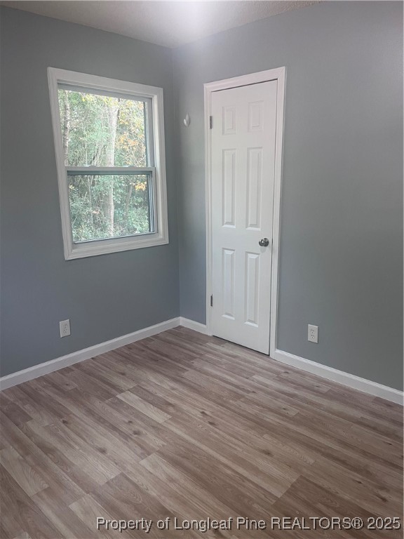 302 Keith Avenue Raeford, NC 28376 - Photo 10 of 14 an empty room with wooden floor and windows