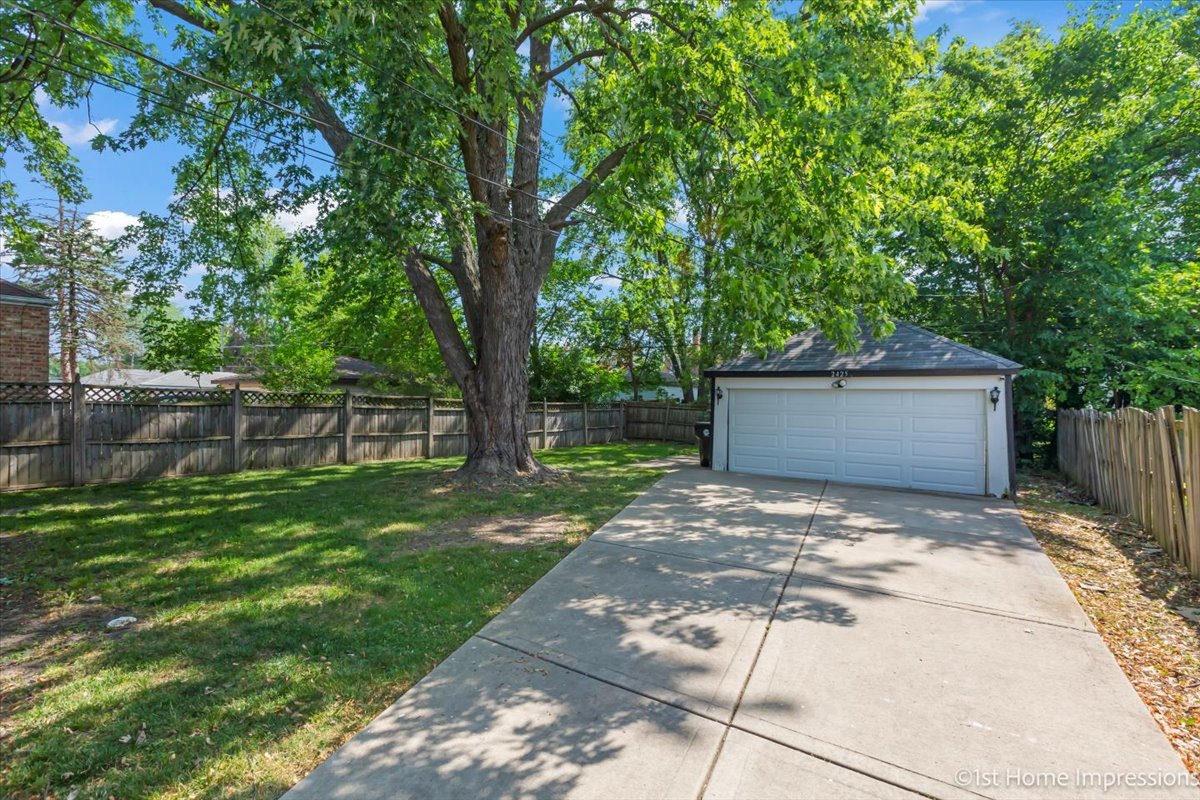 2425 South 13th Avenue Broadview, IL 60155 - Photo 12 of 13 a backyard of a house with large trees and wooden fence