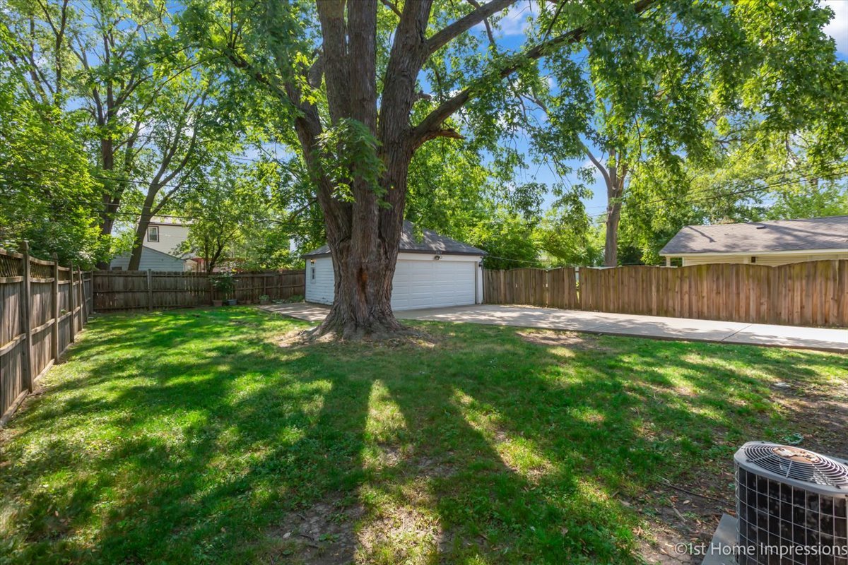 2425 South 13th Avenue Broadview, IL 60155 - Photo 13 of 13 a view of a backyard with large trees and wooden fence