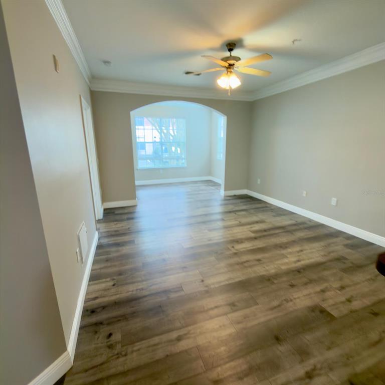 12861 Madison Pointe Circle, Unit 101 Orlando, FL 32821 - Photo 11 of 30 wooden floor in an empty room with a window