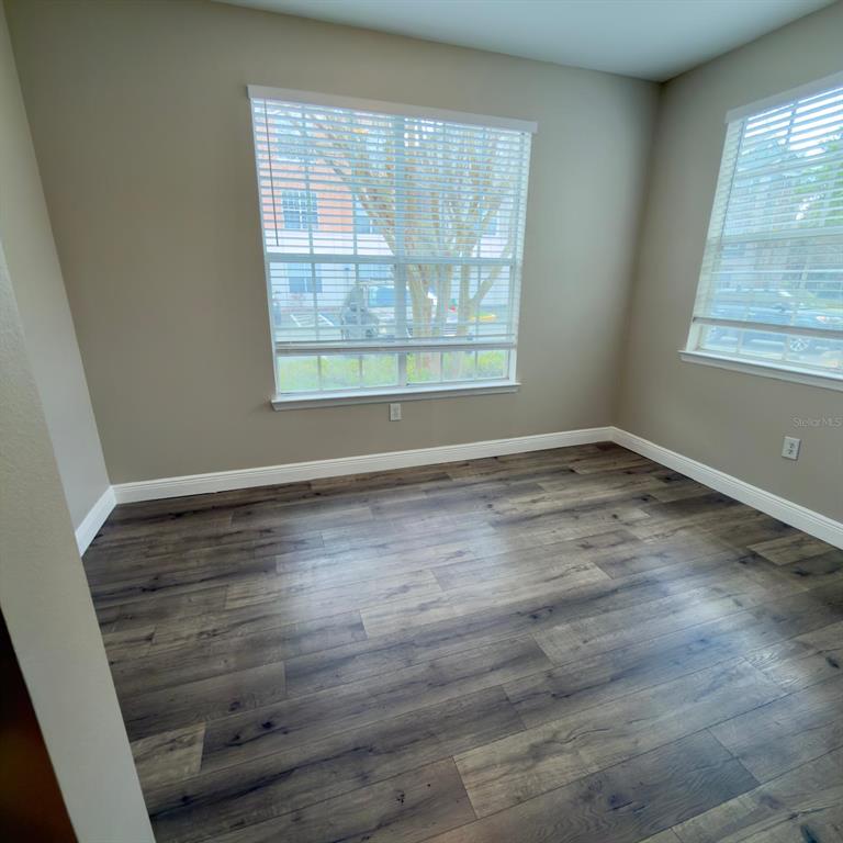 12861 Madison Pointe Circle, Unit 101 Orlando, FL 32821 - Photo 14 of 30 an empty room with wooden floor and windows