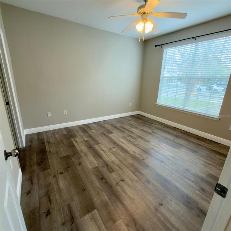 12861 Madison Pointe Circle, Unit 101 Orlando, FL 32821 - Photo 15 of 30 wooden floor in an empty room with a window