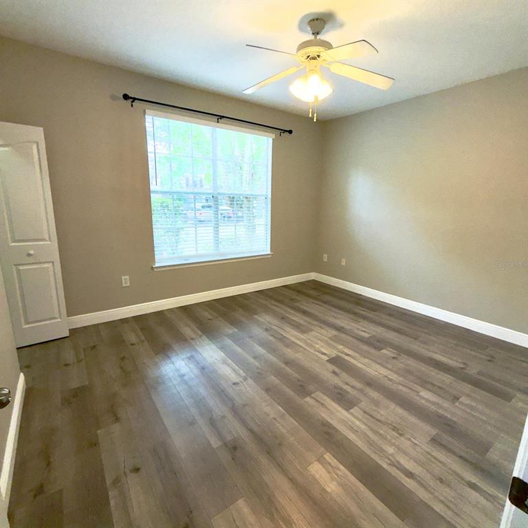12861 Madison Pointe Circle, Unit 101 Orlando, FL 32821 - Photo 22 of 30 wooden floor in an empty room with a window