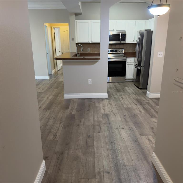 12861 Madison Pointe Circle, Unit 101 Orlando, FL 32821 - Photo 4 of 30 a kitchen with a refrigerator a stove top oven a sink and dishwasher