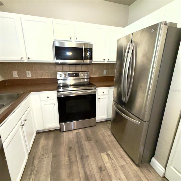 12861 Madison Pointe Circle, Unit 101 Orlando, FL 32821 - Photo 5 of 30 a kitchen with stainless steel appliances granite countertop a refrigerator microwave and sink