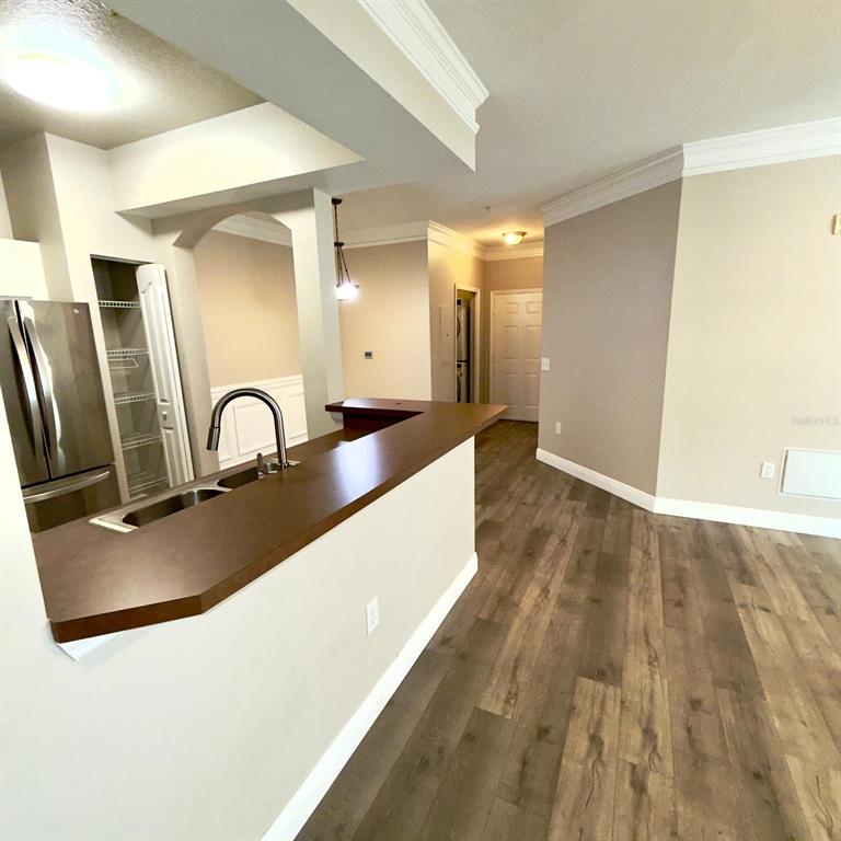 12861 Madison Pointe Circle, Unit 101 Orlando, FL 32821 - Photo 10 of 30 a kitchen with kitchen island a sink and wooden floor