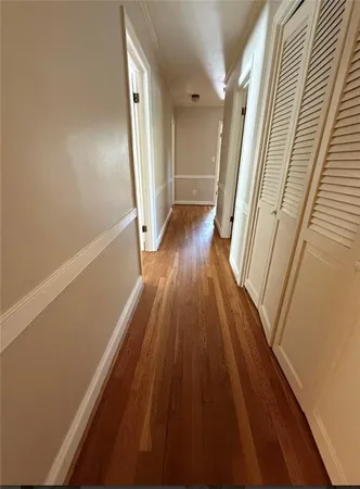 a view of a hallway with wooden floor and staircase