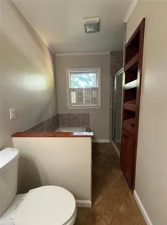 a bathroom with a sink a toilet a window and shower