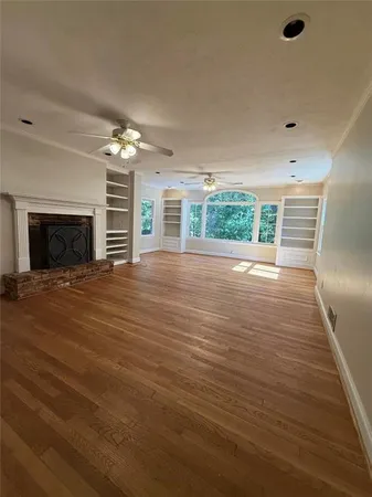 an empty room with wooden floor and fireplace
