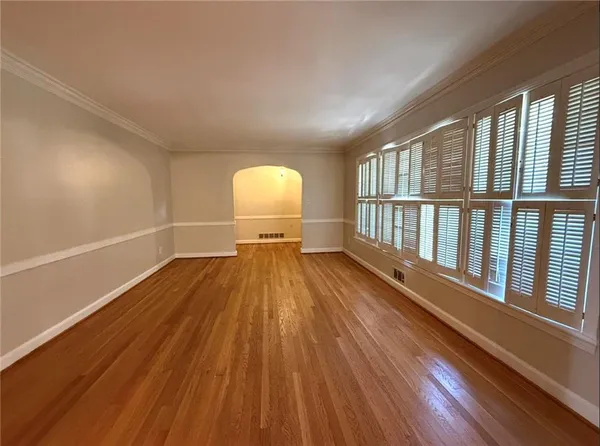 a view of empty room with wooden floor