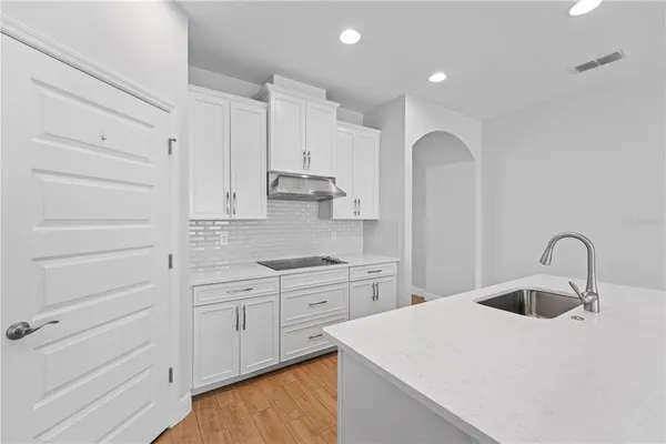 a kitchen with kitchen island a sink appliances and a counter top space