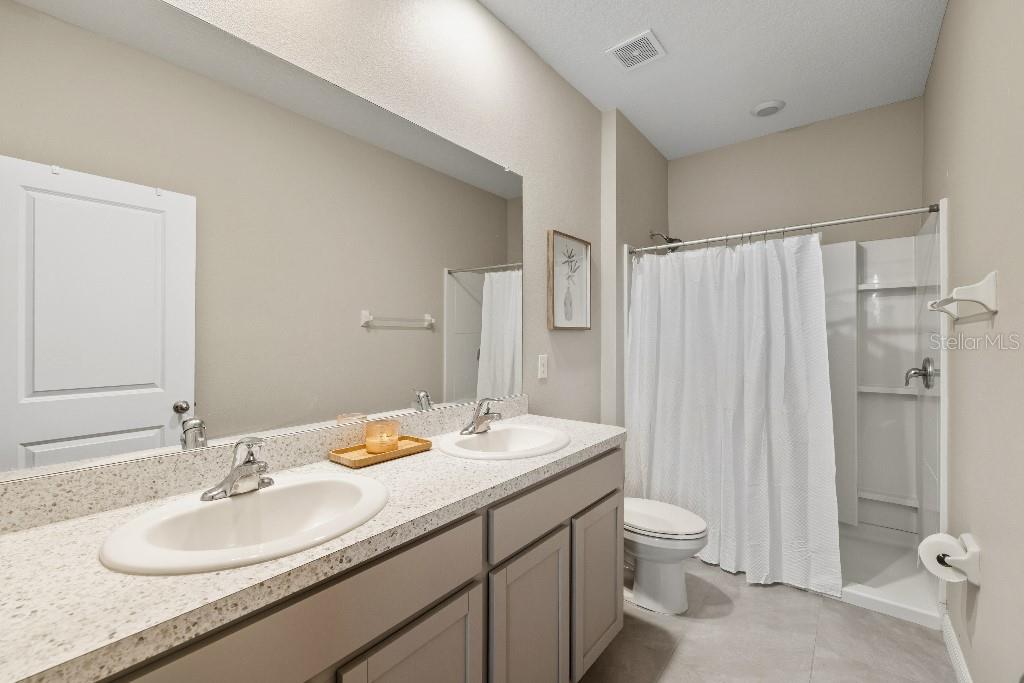 13664 Northwest 9th Road Newberry, FL 32669 - Photo 14 of 33 a bathroom with a double vanity sink toilet and shower