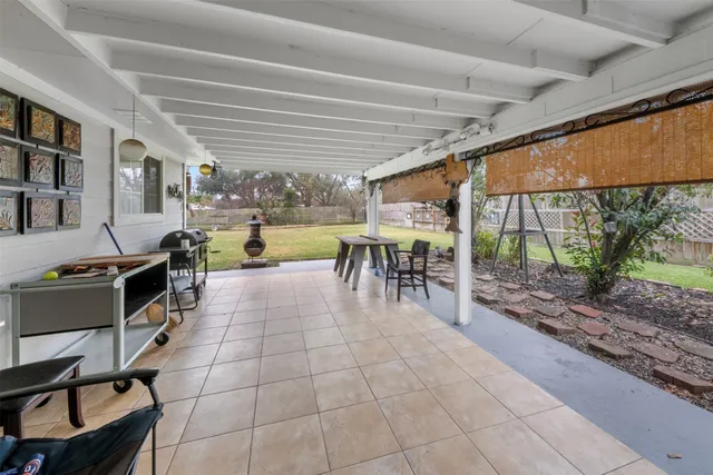 a dining hall with stainless steel appliances granite countertop a table chairs and a view of living room