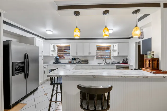 a kitchen with stainless steel appliances granite countertop a sink and a refrigerator