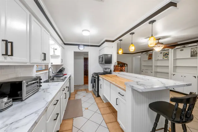 a large kitchen with stainless steel appliances granite countertop a stove and cabinets