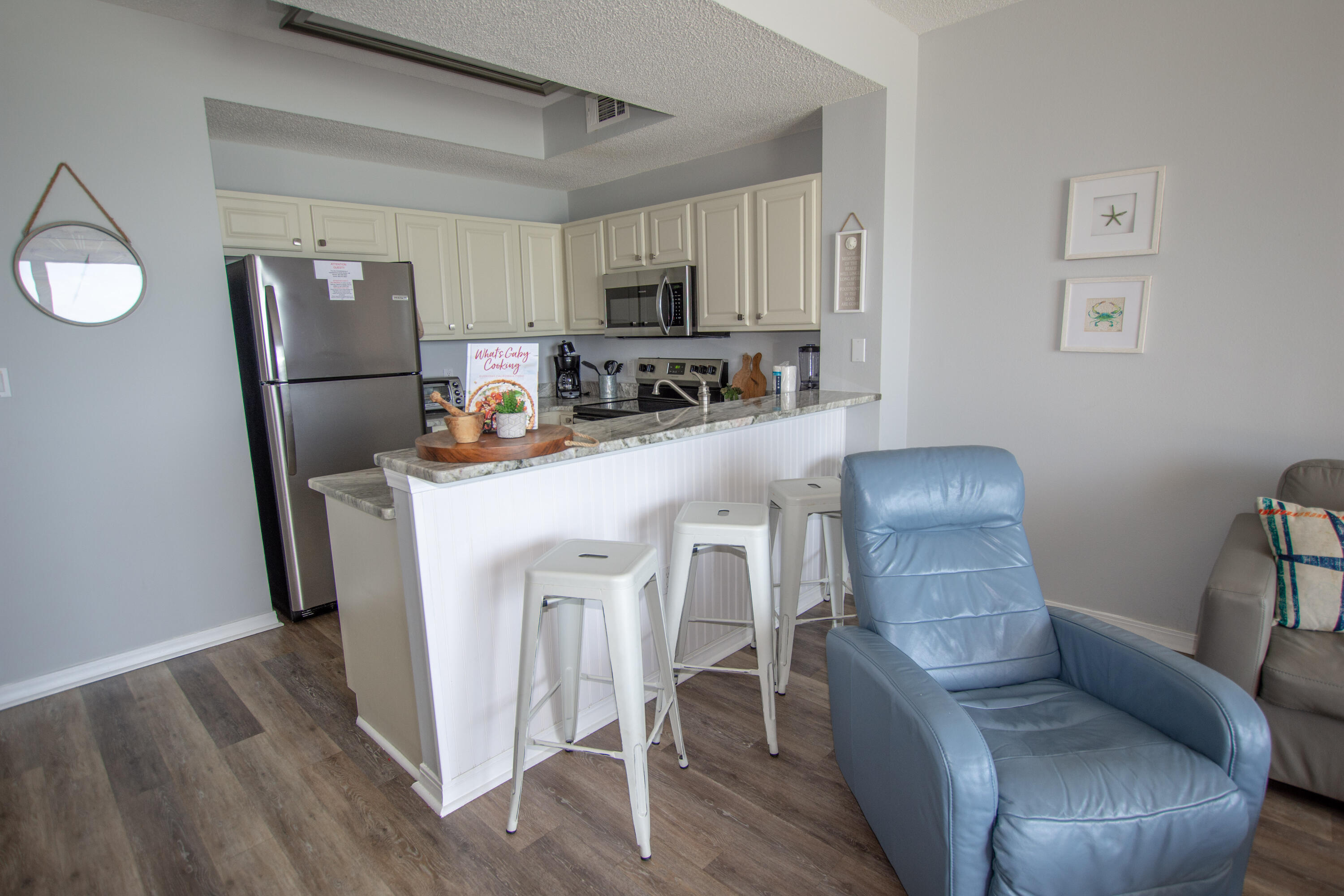 376 Santa Rosa Boulevard, Unit 507 Fort Walton Beach, FL 32548 - Photo 15 of 32 a kitchen with stainless steel appliances granite countertop a refrigerator a stove top oven a sink dishwasher and white cabinets with wooden floor
