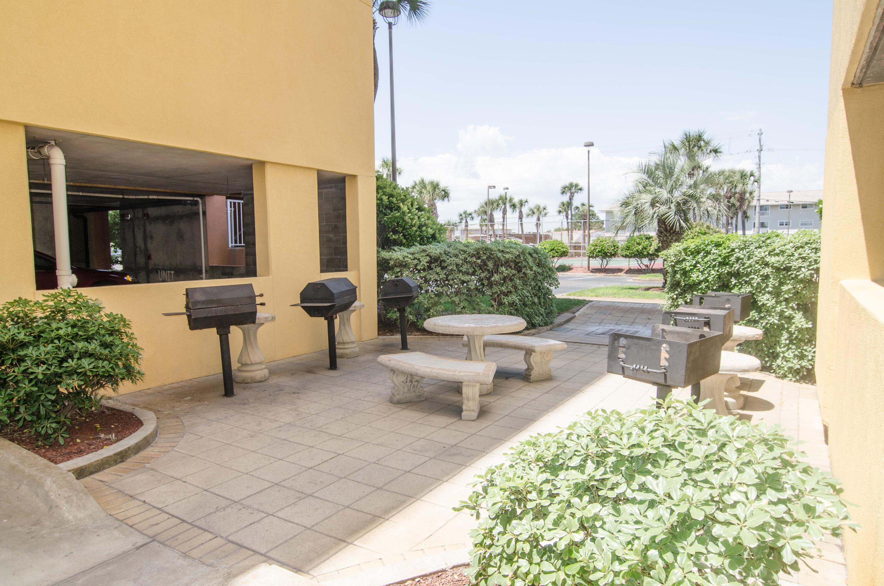 376 Santa Rosa Boulevard, Unit 507 Fort Walton Beach, FL 32548 - Photo 32 of 32 a view of a patio with couches table and chairs and potted plants
