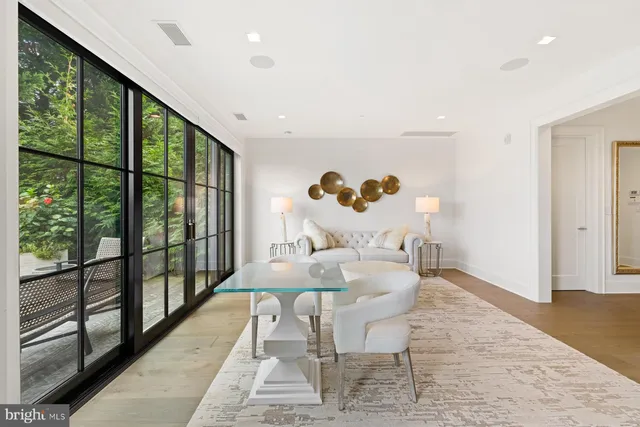 a dining room with wooden floor windows and outdoor view