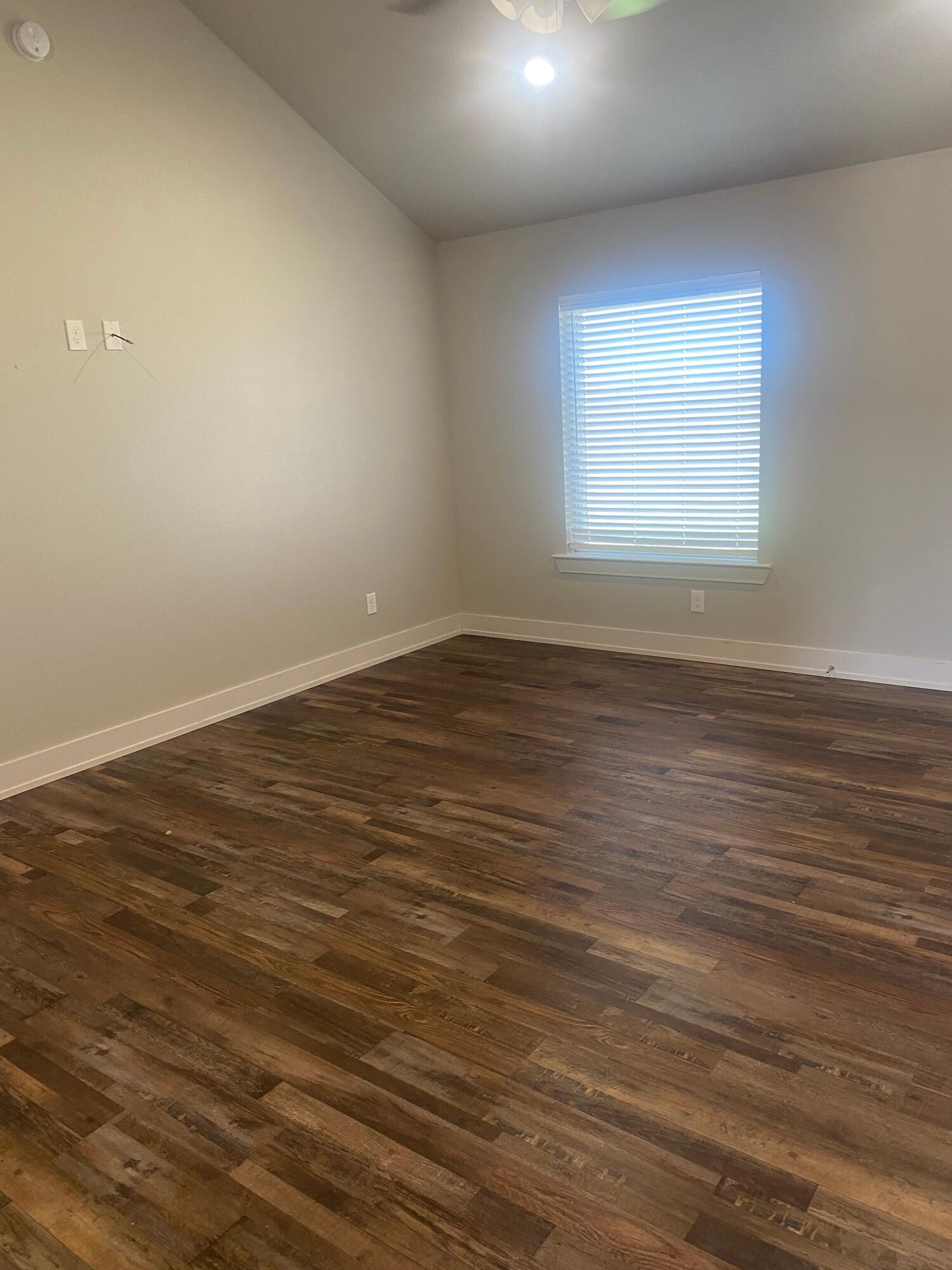 1609 Avenue O, Unit B Shallowater, TX 79363 - Photo 12 of 12 an empty room with wooden floor and windows