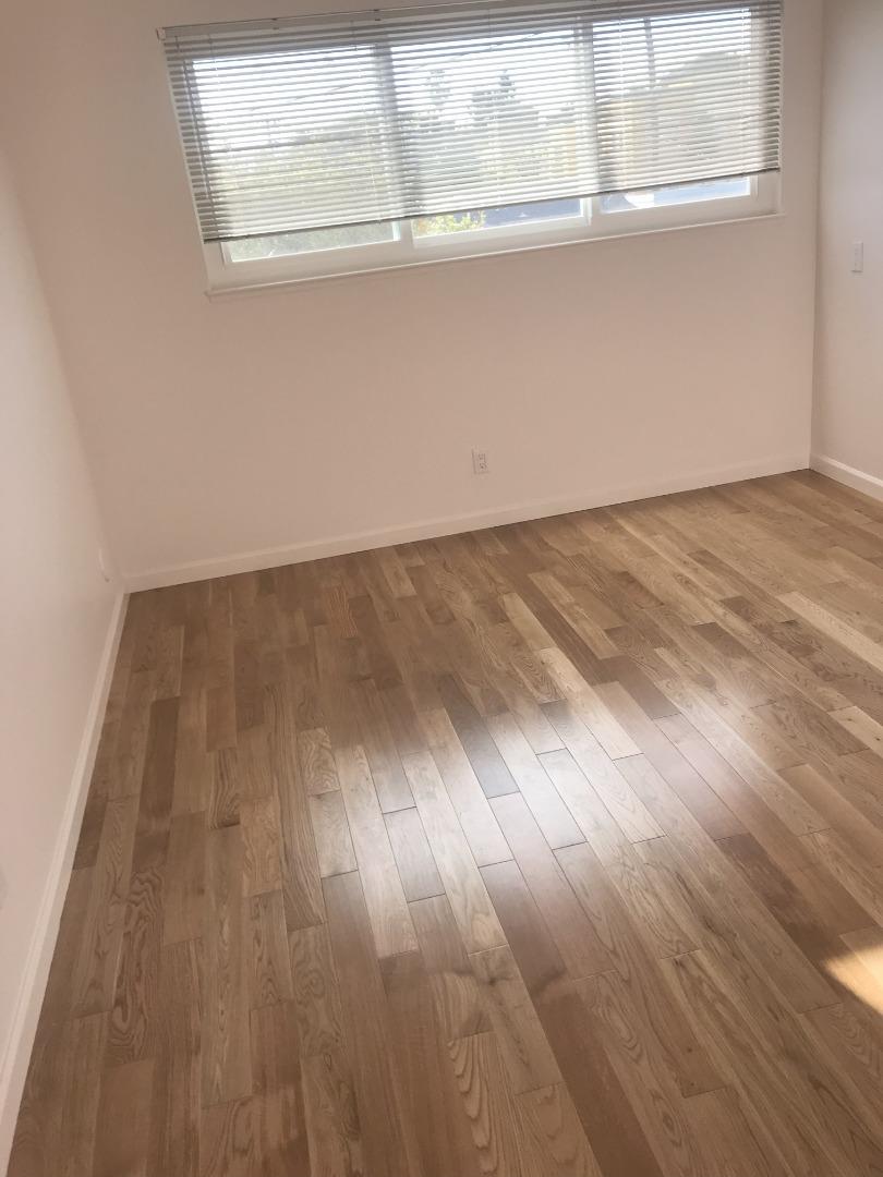 2469 Olive Avenue San Jose, CA 95128 - Photo 5 of 10 an empty room with wooden floor and windows
