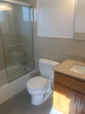a white toilet sitting next to a bath tub and shower