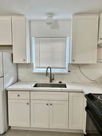a kitchen with white cabinets and a sink