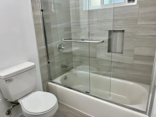 a white toilet and tub sitting next to a shower