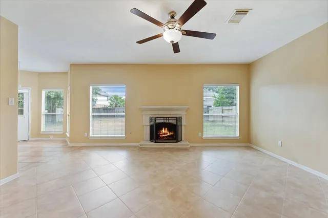 an empty room with windows and fireplace