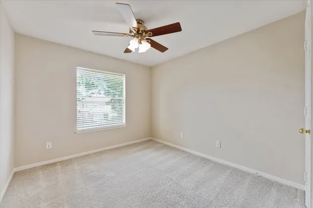 an empty room with a chandelier fan and a ceiling fan