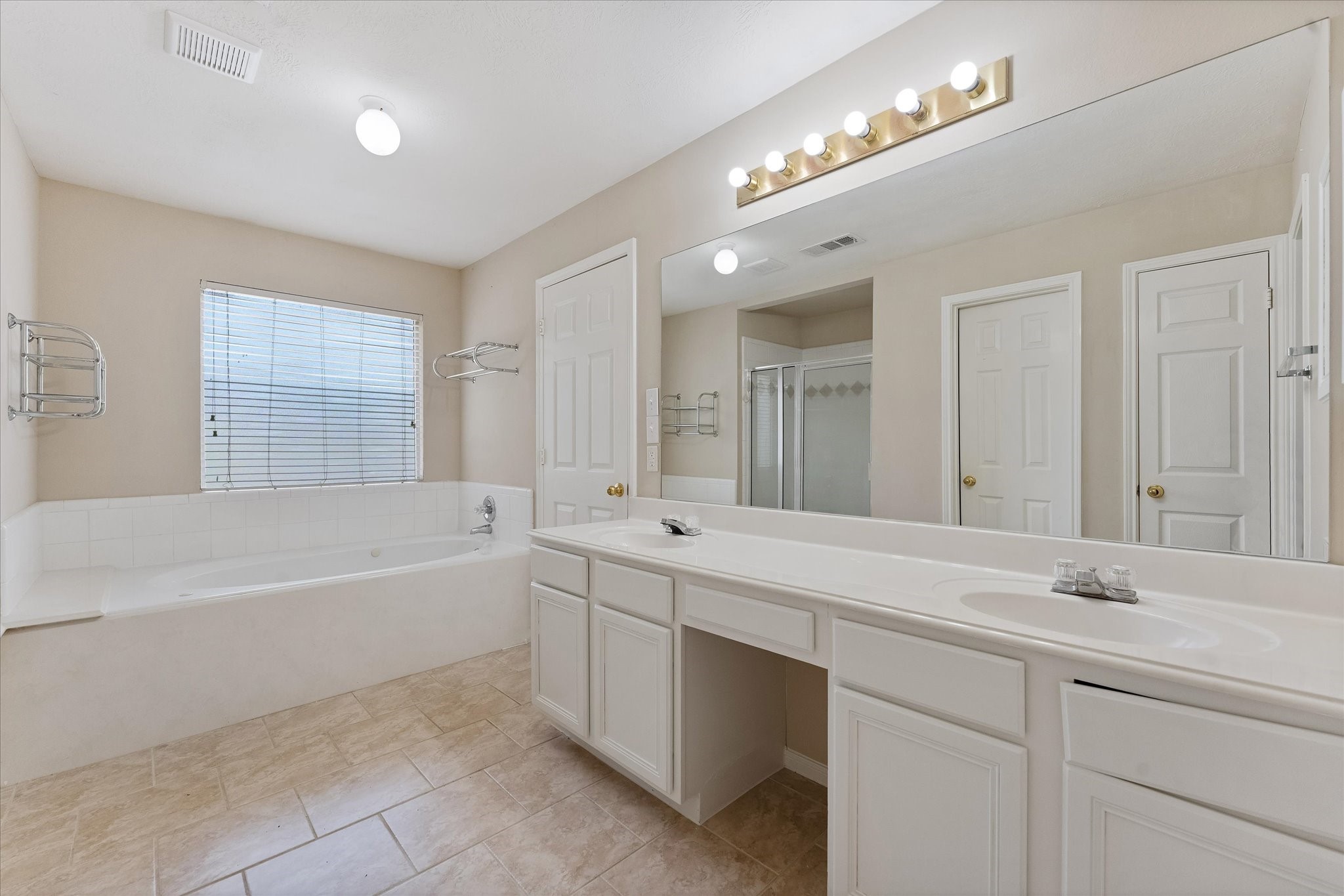 23806 Spring Way Drive Spring, TX 77373 - Photo 33 of 44 a bathroom with a tub a sink and a large mirror