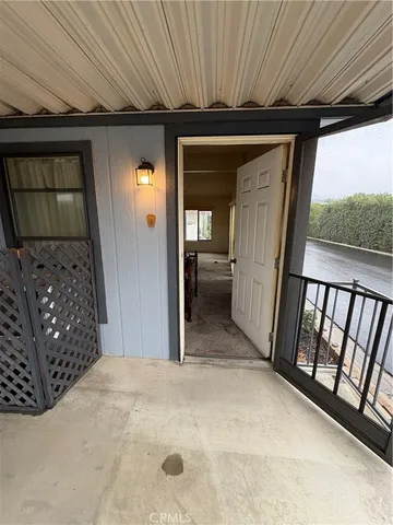 a view of an empty room with wooden floor and chair