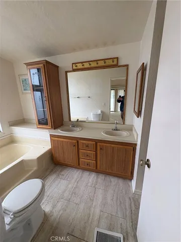 a bathroom with a granite countertop sink mirror vanity and toilet