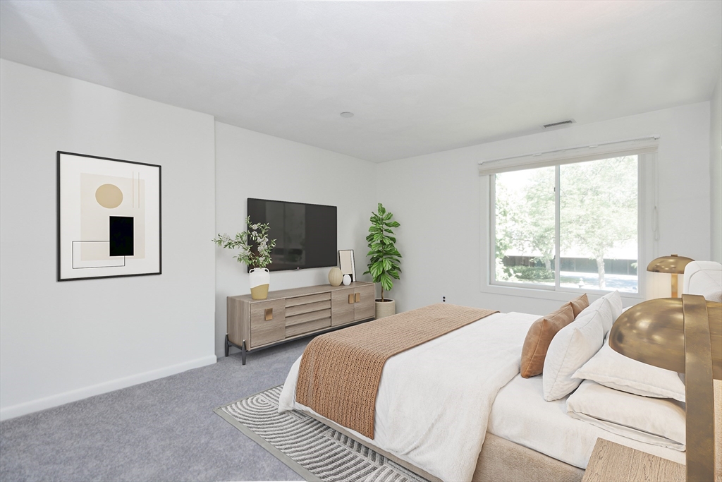 8 Concord Greene, Unit 4 Concord, MA 01742 - Photo 13 of 42 a bedroom with a bed and a flat screen tv