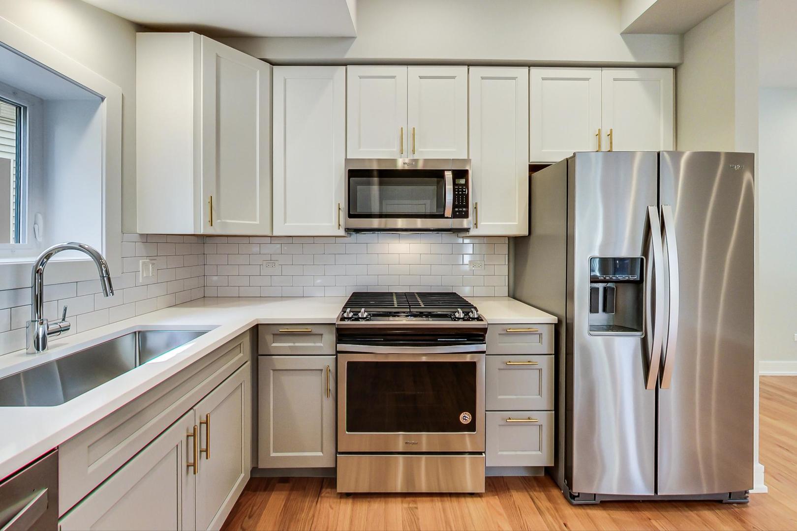 3534 West Wrightwood Avenue, Unit 1F Chicago, IL 60647 - Photo 2 of 18 a kitchen with cabinets stainless steel appliances and wooden floor