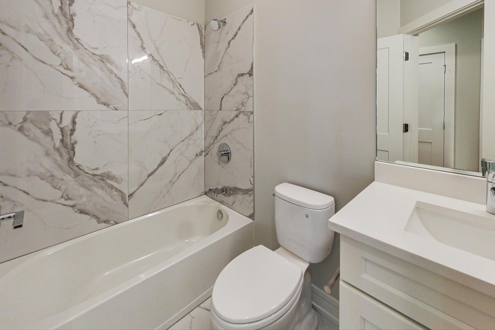 3534 West Wrightwood Avenue, Unit 1F Chicago, IL 60647 - Photo 12 of 18 a white toilet and tub sitting next to a bathroom sink