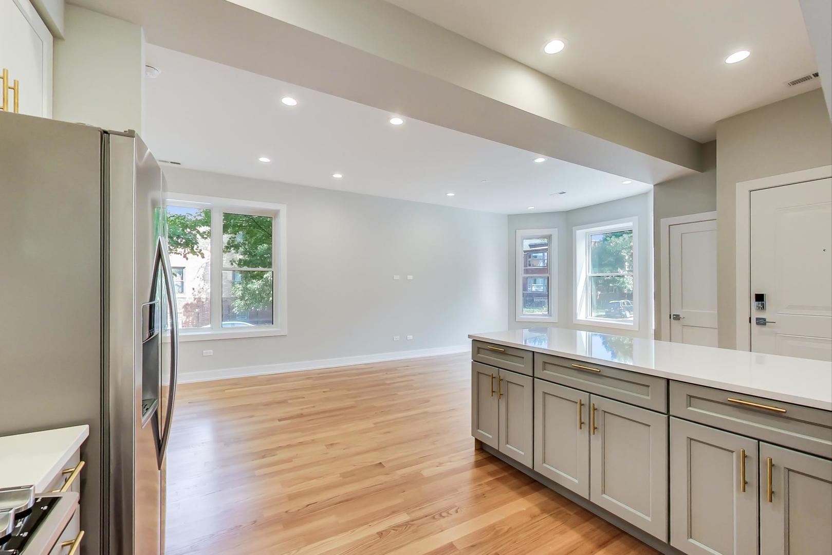 3534 West Wrightwood Avenue, Unit 1F Chicago, IL 60647 - Photo 6 of 18 a view of a kitchen counter space with wooden floor and staircase
