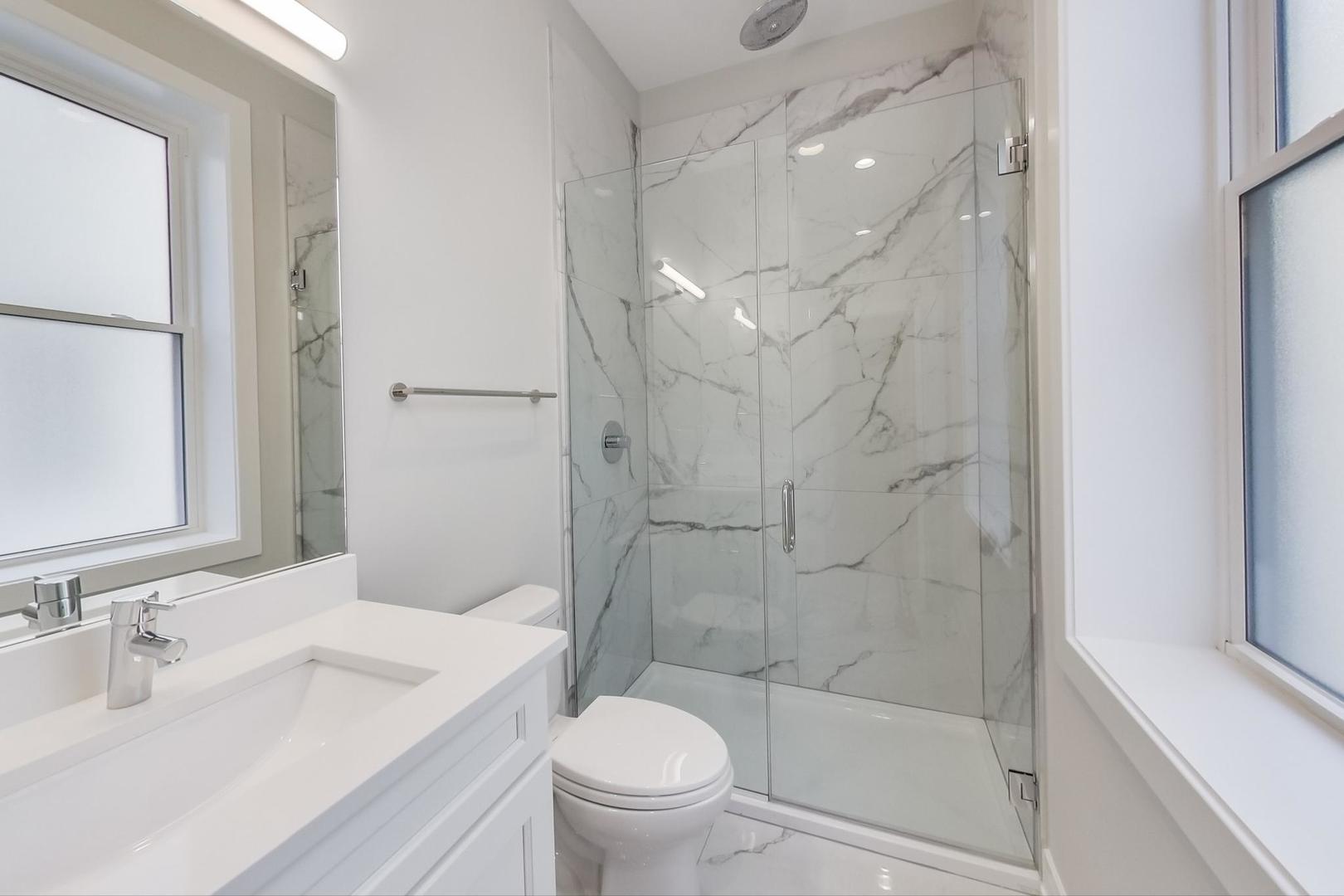 3534 West Wrightwood Avenue, Unit 1F Chicago, IL 60647 - Photo 9 of 18 a bathroom with a sink a toilet and shower