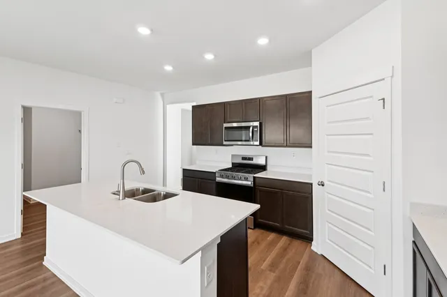 a kitchen with granite countertop a stove top oven and sink
