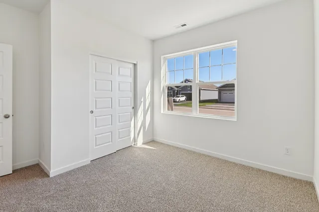 an empty room with windows and closet
