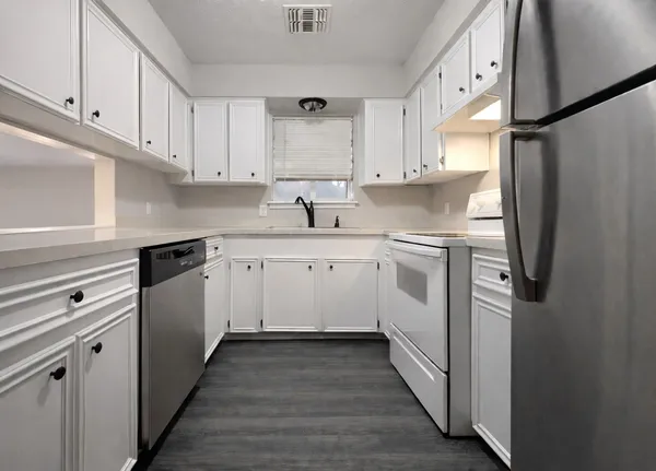 a kitchen with white cabinets and white appliances