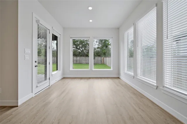 a view of a garden with wooden floor and windows