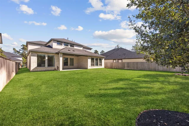 a view of a big house with a big yard and large trees